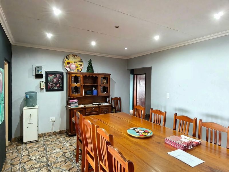 A spacious dining room featuring tiled flooring, recessed downlighting, and coved ceiling cornices, providing a functional area for family meals.