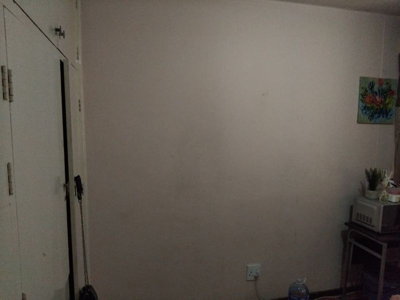 A bedroom interior featuring built-in cupboards and neutral wall finishes, providing a blank canvas for potential interior design updates.