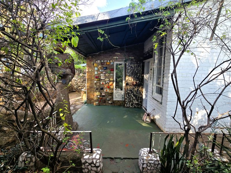 A covered outdoor patio area featuring painted brick walls and stone masonry elements, offering a rustic space for outdoor relaxation.