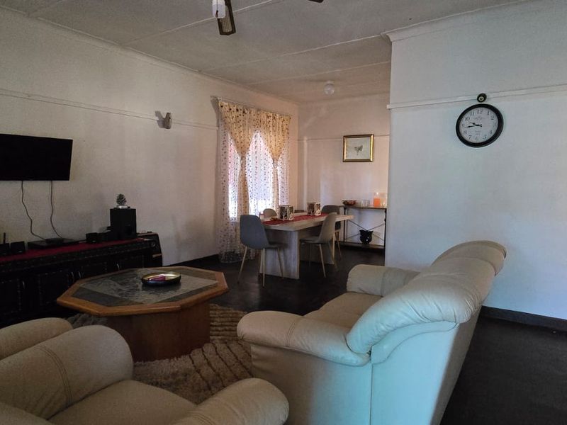 An open-plan living and dining area featuring traditional picture rails and coving, providing a functional space for relaxation and family meals.