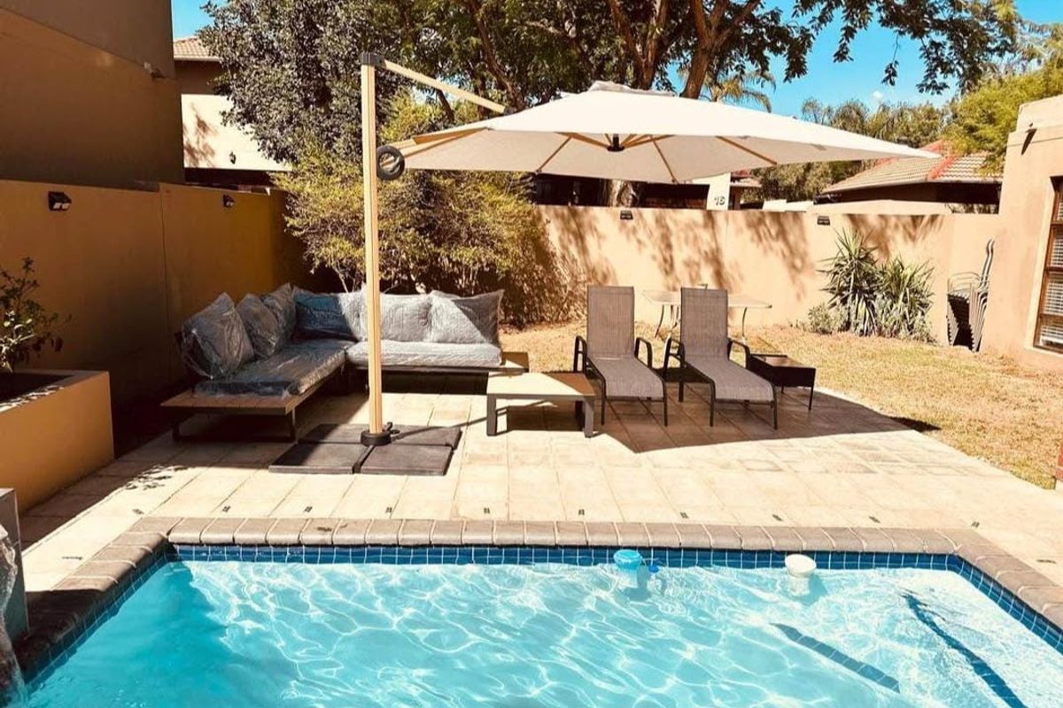 A private outdoor pool area featuring a paved patio space, ideal for relaxation and outdoor entertainment within a secure boundary wall setting.