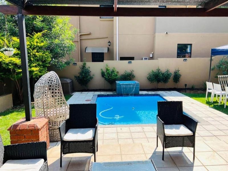 A private outdoor pool area featuring a tiled patio, water feature, and timber pergola, perfect for relaxation and outdoor entertaining.