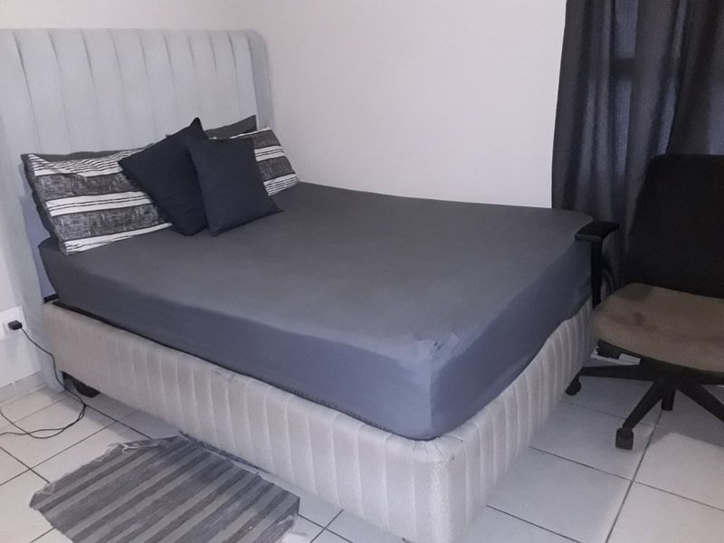 A bedroom featuring tiled flooring and a neutral wall finish, providing a functional space for rest.
