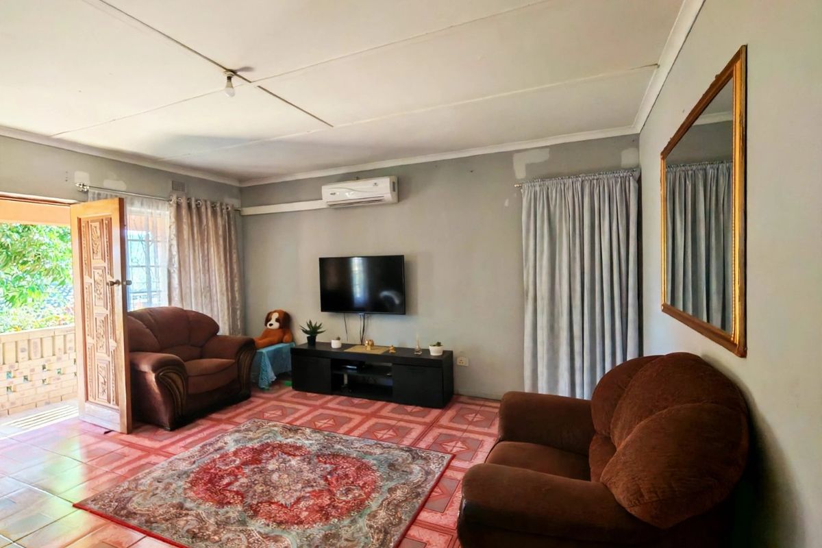 A living room featuring tiled flooring, a split-system air conditioner, and direct access to an outdoor patio area.