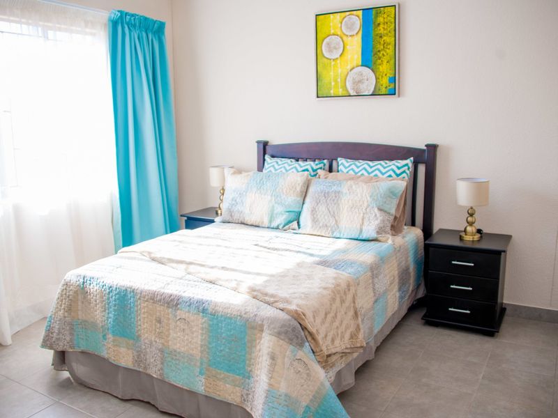 A well-maintained bedroom featuring neutral wall finishes and durable tiled flooring, providing a clean and functional living space.