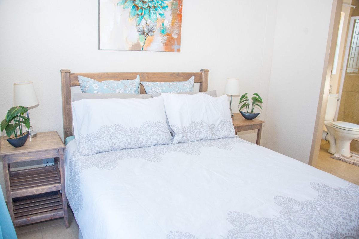 A bedroom featuring tiled flooring and direct access to an en-suite bathroom.