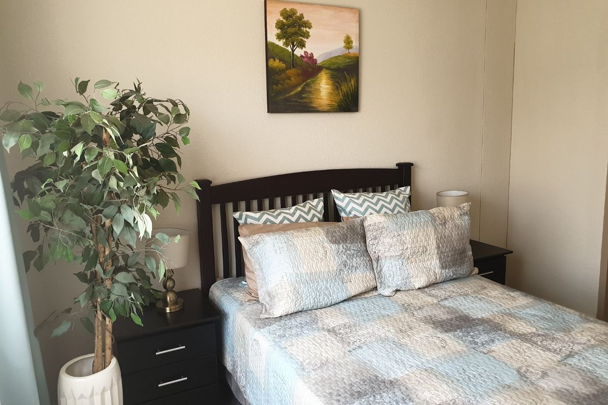 A cozy bedroom featuring neutral wall tones and a functional layout, suitable for a comfortable sleeping space.