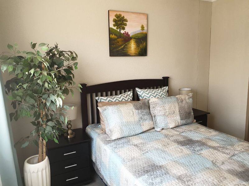 A cozy bedroom featuring neutral wall tones and a functional layout, suitable for a comfortable sleeping space.