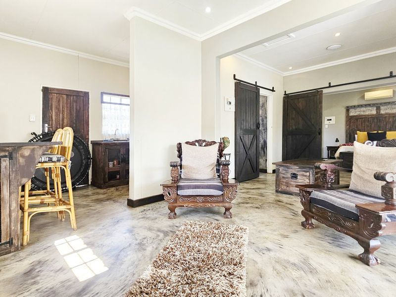 Open-plan living area featuring polished concrete floors, rustic barn-style sliding doors, and recessed lighting, creating a cohesive and functional commercial space.