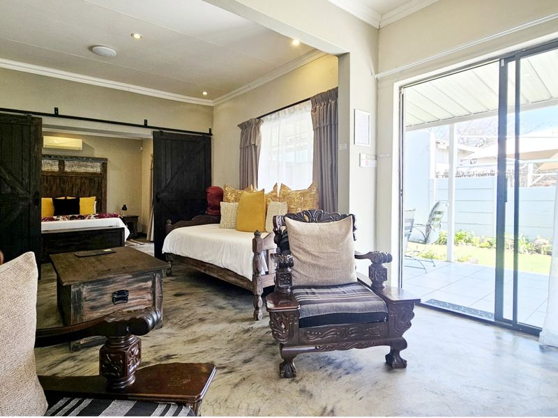 Spacious open-plan living area featuring polished concrete floors, recessed lighting, and sliding glass doors providing seamless access to the outdoor patio.