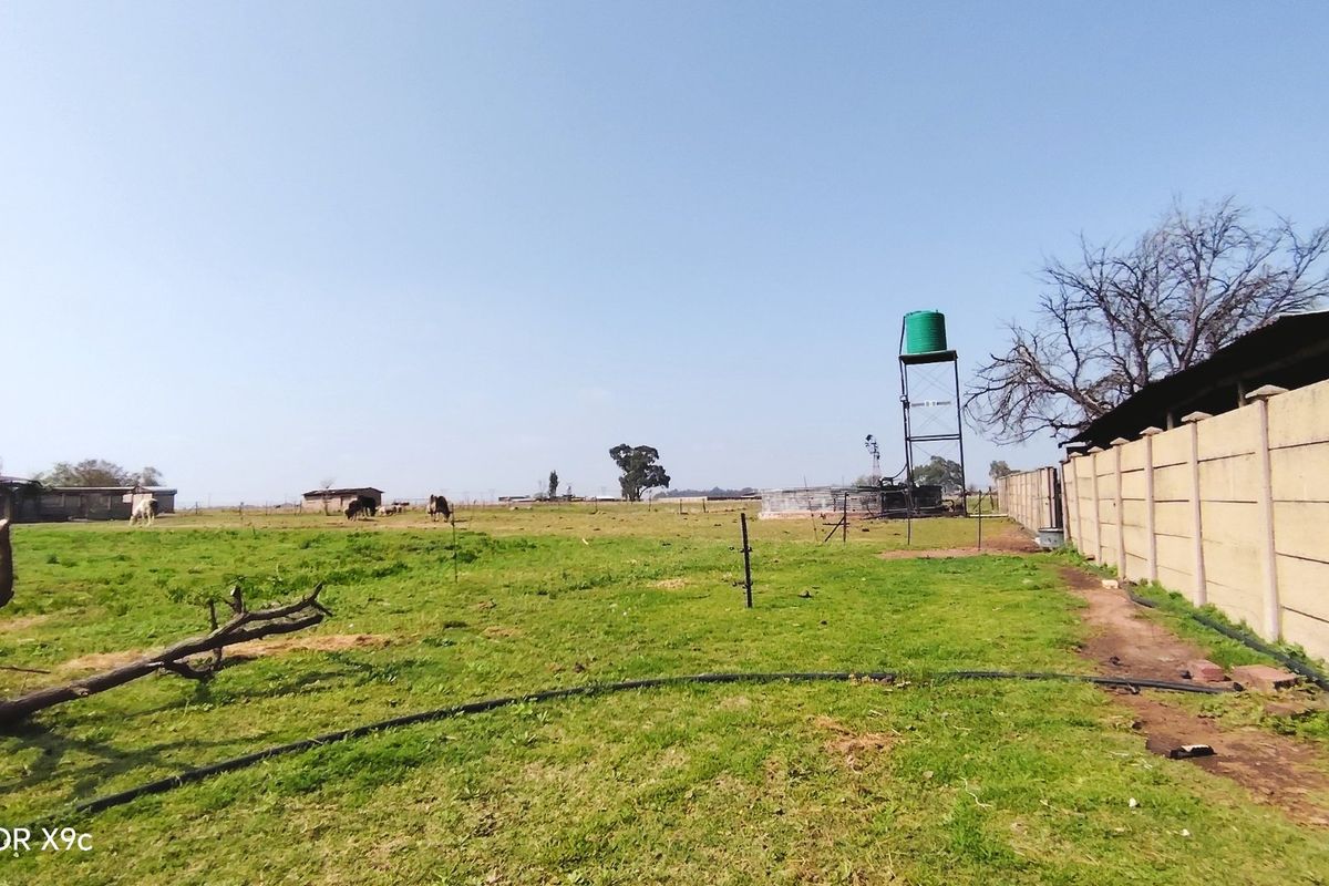 Expansive farm land featuring a water tank tower and perimeter precast concrete walling.