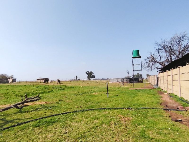 Expansive farm land featuring a water tank tower and perimeter precast concrete walling.