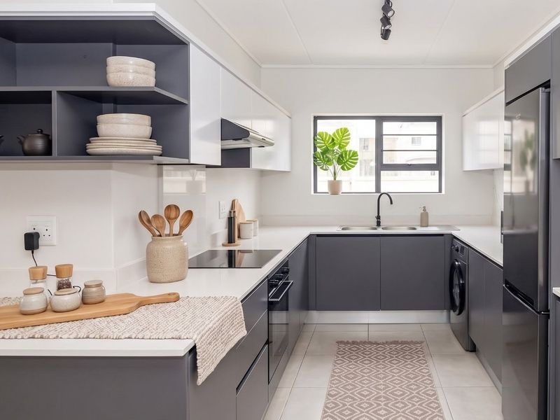 Modern, well-appointed kitchen featuring sleek grey and white cabinetry, quartz countertops, integrated appliances, and high-quality finishes throughout.