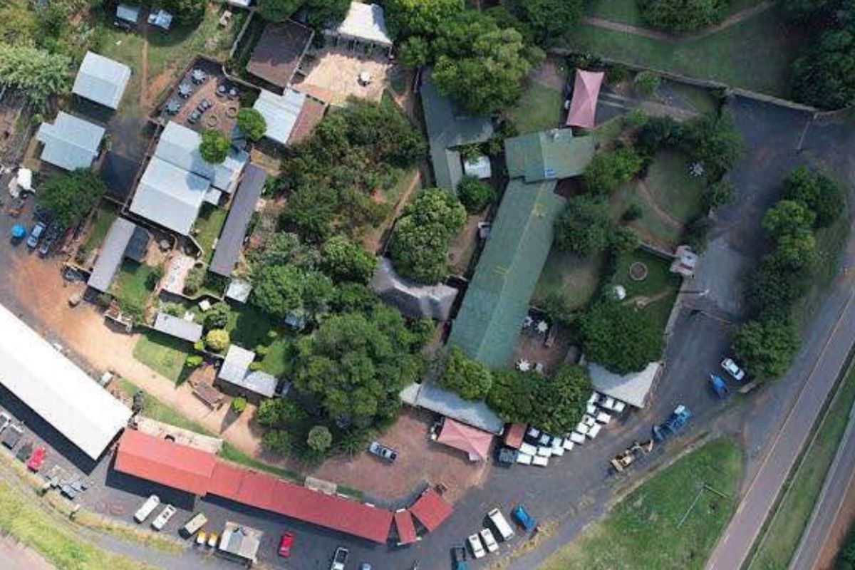 Aerial view of a commercial property complex featuring multiple buildings, extensive parking facilities, and landscaped grounds.