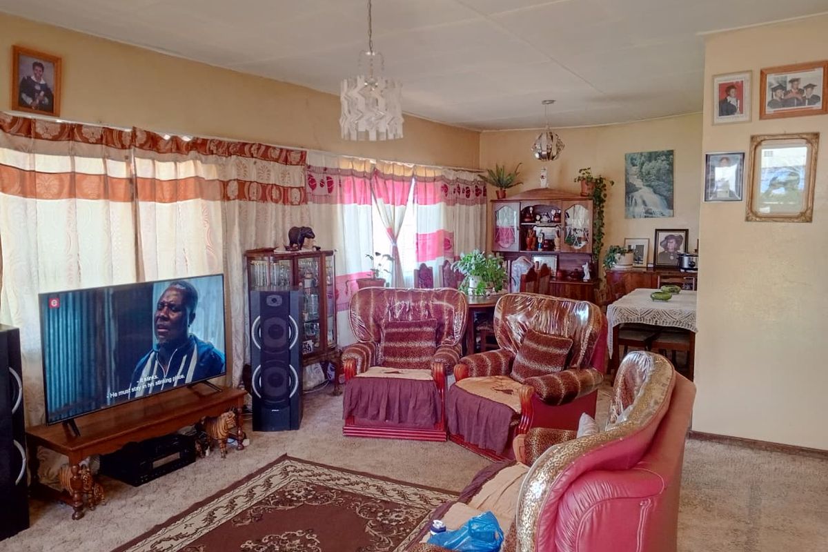 A spacious living room featuring carpeted flooring and multiple ceiling light fixtures, offering a comfortable and functional layout for relaxation.