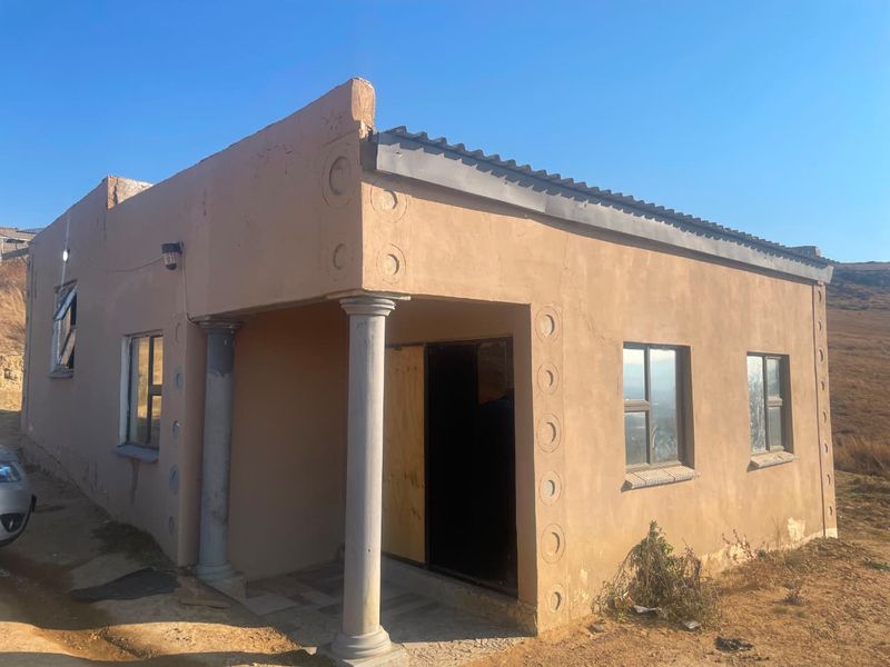 Single-story residential property featuring a plastered exterior, concrete columns, and aluminum window frames, requiring exterior maintenance and finishing.