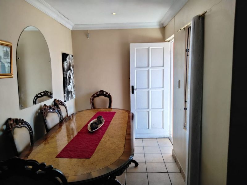 Dining room featuring tiled flooring, coved cornicing, and direct access to the exterior through a panelled door.