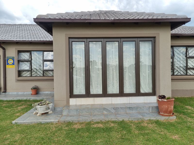 Rear exterior view featuring a tiled patio area with folding glass doors and secure window frames.