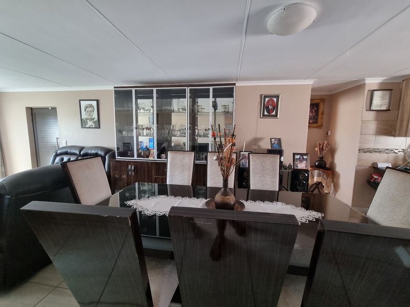 A dining area featuring tiled flooring and a built-in display cabinet, providing a functional space for meals and storage.