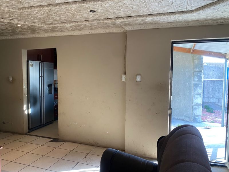 Living area featuring tiled flooring and a textured ceiling, with direct access to an outdoor patio area.