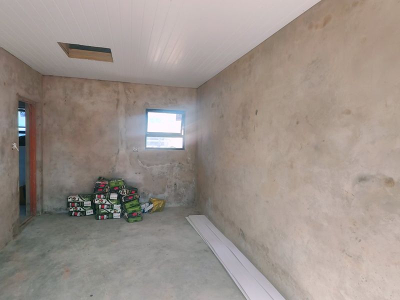 An unfinished bedroom space featuring raw plastered walls, concrete flooring, and a white ceiling with an access hatch.