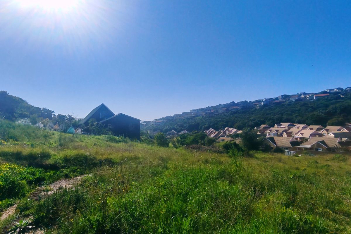 A wide-angle view of the vacant residential land, showcasing the surrounding landscape, natural vegetation, and neighboring residential developments.