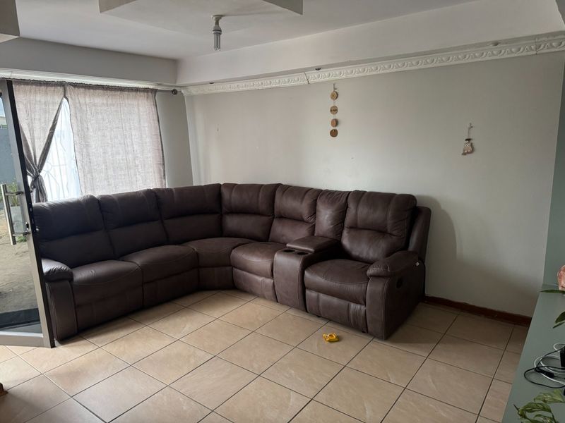 A living room featuring ceramic floor tiles, decorative ceiling cornicing, and a sliding glass door providing access to the exterior.