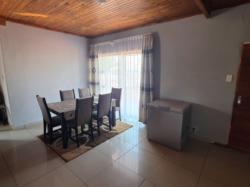 Dining area featuring tiled flooring, a timber-clad ceiling, and a sliding glass door providing access to the exterior.