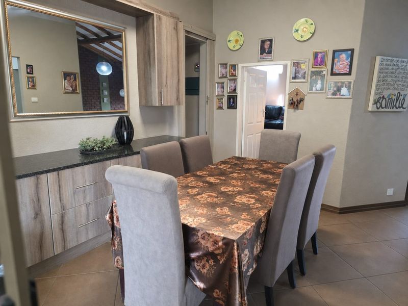 Dining area featuring tiled flooring, built-in cabinetry with granite countertop, and a wall-mounted mirror, providing a functional space for meals.
