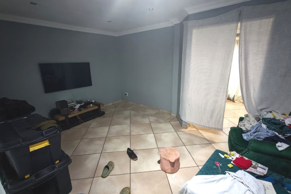 A living room featuring tiled flooring, recessed downlights, and coved cornicing, providing a functional base for interior design updates.
