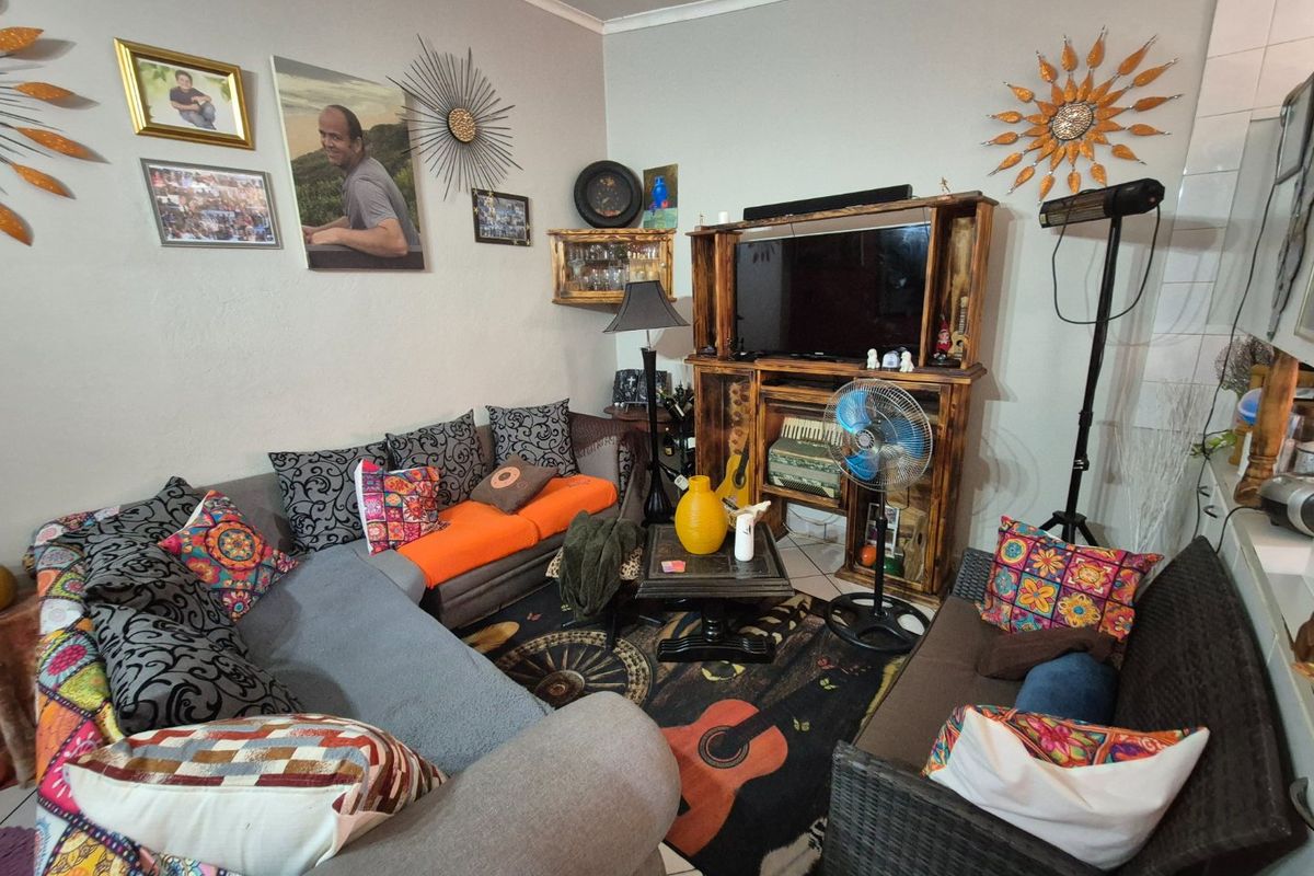 A living room area featuring tiled flooring and coved ceiling details, providing a functional space for relaxation.