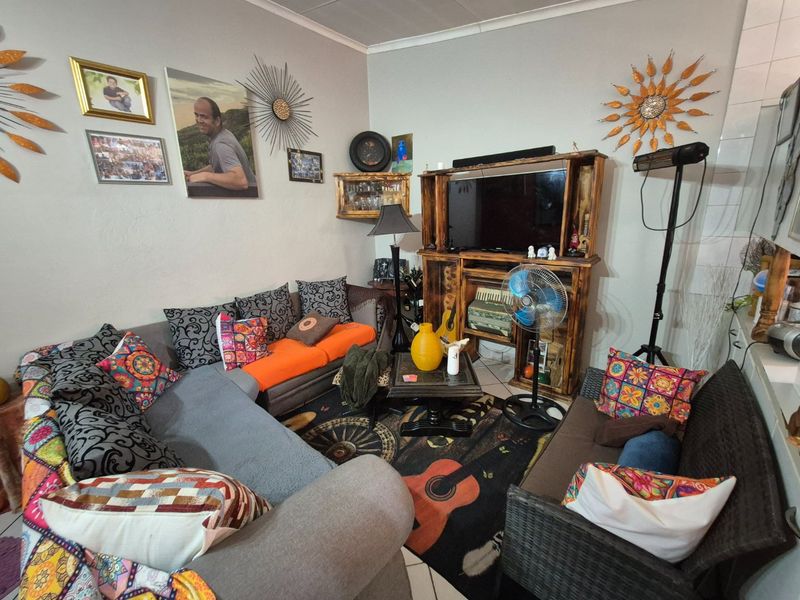 A living room area featuring tiled flooring and coved ceiling details, providing a functional space for relaxation.
