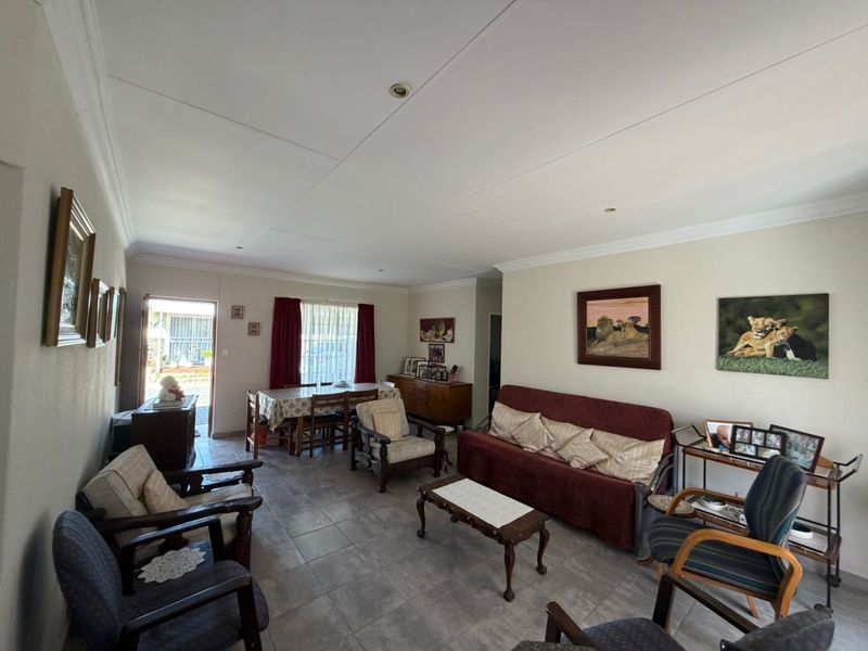Spacious open-plan living and dining area featuring neutral tiled flooring, recessed lighting, and direct access to the exterior.