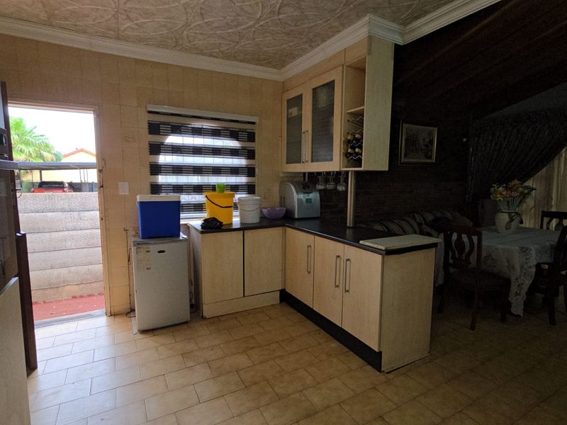 A functional kitchen area featuring built-in cabinetry, tiled flooring, and a built-in oven, with direct access to the exterior.