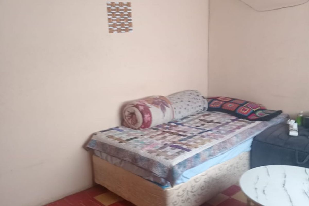 A bedroom featuring a timber ceiling, tiled flooring, and a central light fixture. The space requires cosmetic updates to improve its overall condition.