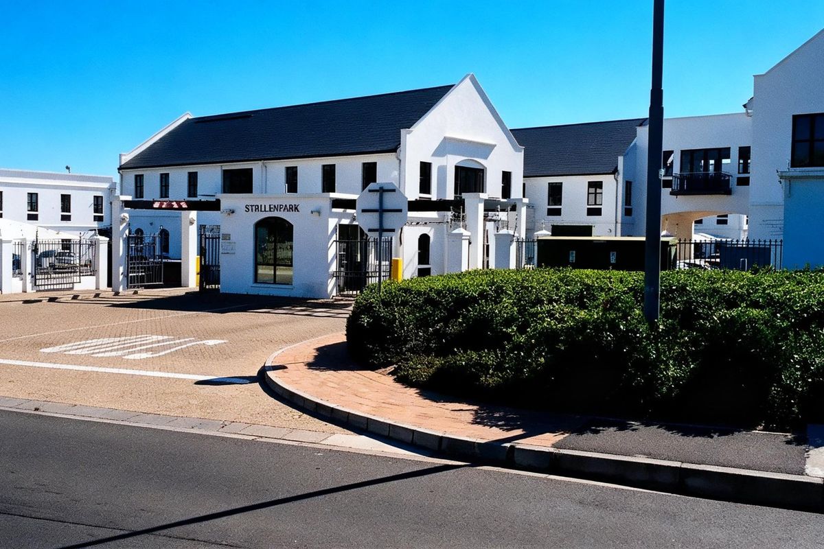 Front exterior view of the Strillenpark commercial complex, featuring a secure gated entrance, paved driveway, and well-maintained building facades.