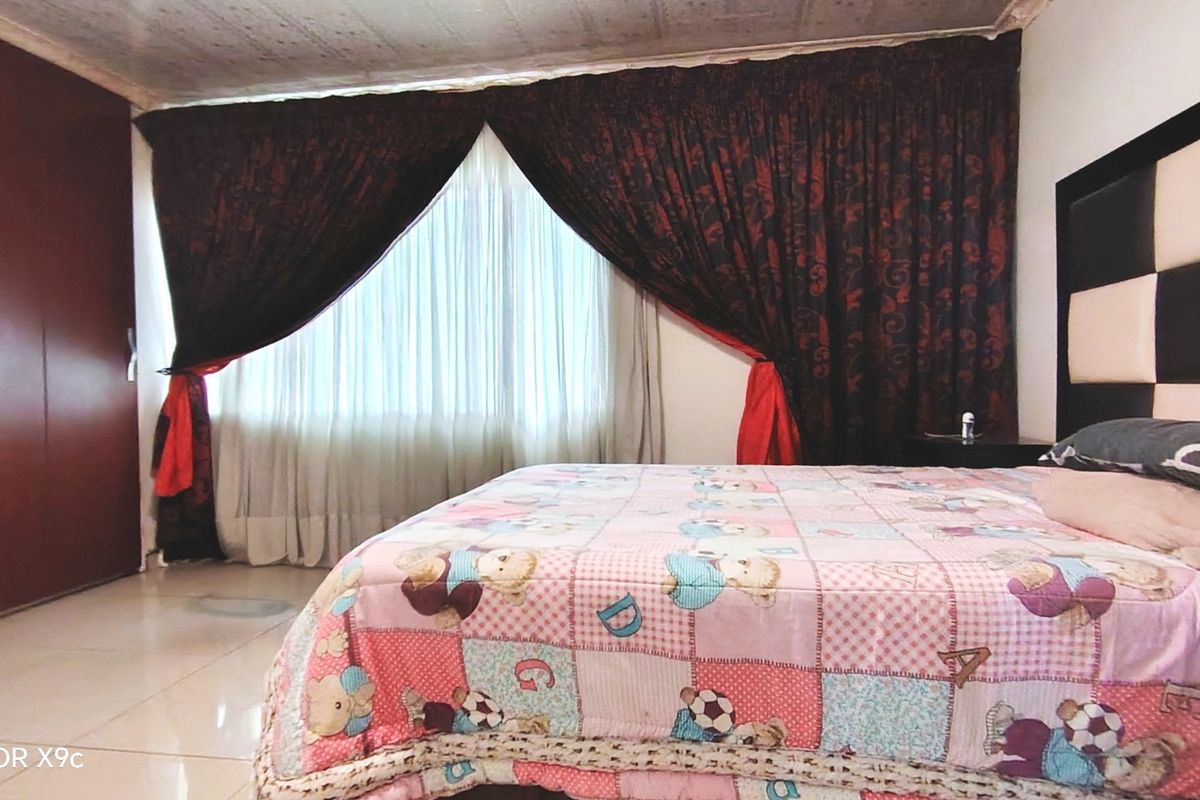 A bedroom featuring tiled flooring and a large built-in wardrobe, providing functional storage space.