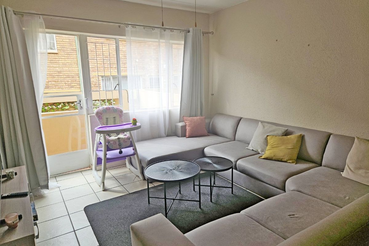 A living room featuring tiled flooring, a ceiling fan, and a sliding glass door providing access to the exterior.
