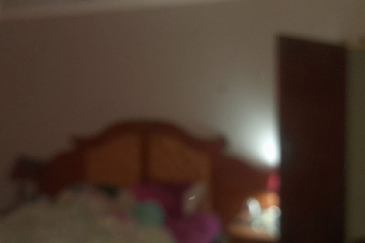 A bedroom featuring a built-in cupboard, captured in a low-quality, blurry image.