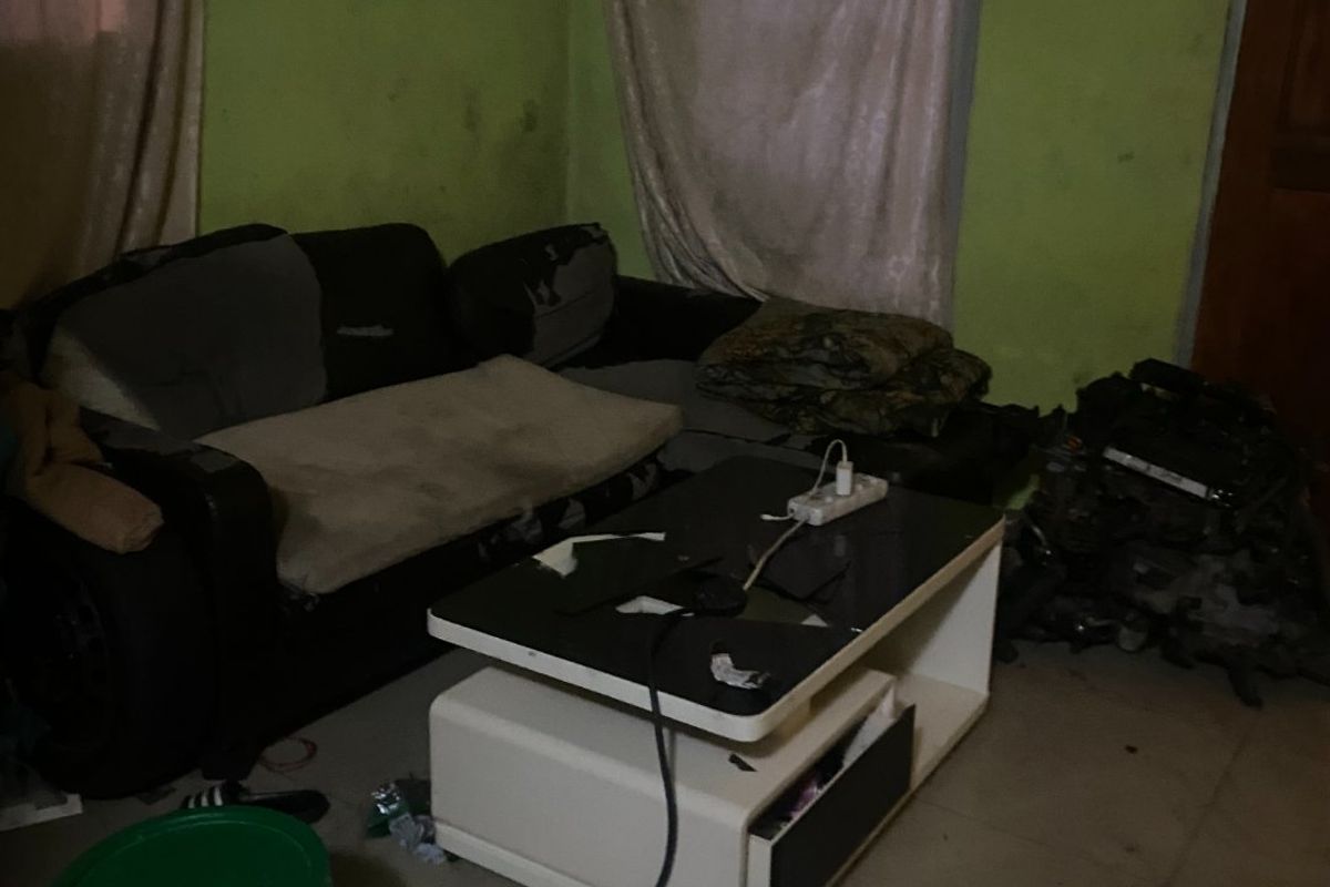A living room space featuring tiled flooring and painted walls in need of maintenance and cosmetic updates.