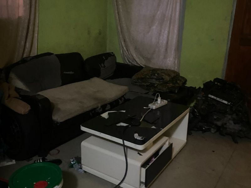 A living room space featuring tiled flooring and painted walls in need of maintenance and cosmetic updates.