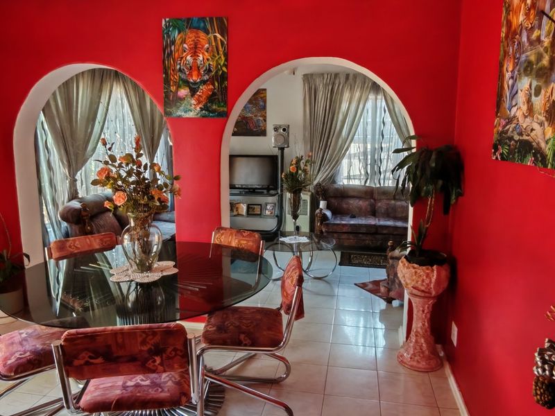 Open plan living and dining area featuring distinctive arched doorways and tiled flooring, connecting the two main living spaces.