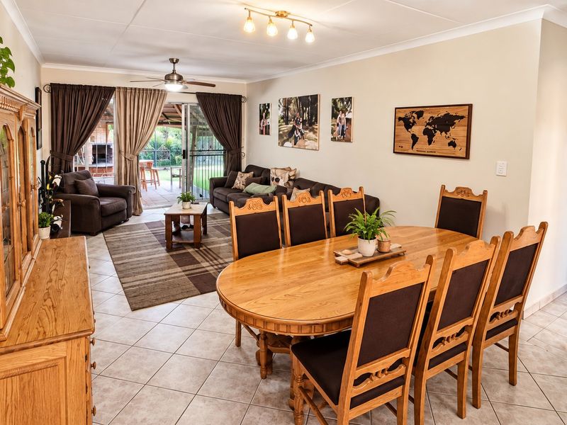 Spacious open-plan living and dining area featuring tiled flooring, ceiling fan, and direct access to the outdoor patio through sliding glass doors.