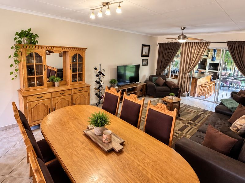 Spacious open-plan living and dining area featuring tiled flooring, a ceiling fan, and direct access to an outdoor patio through sliding glass doors.