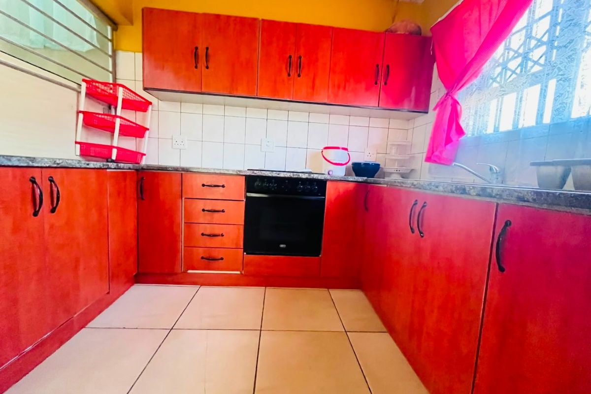 A functional kitchen featuring built-in cabinetry, a built-in oven, hob, tiled backsplash, and tiled flooring.