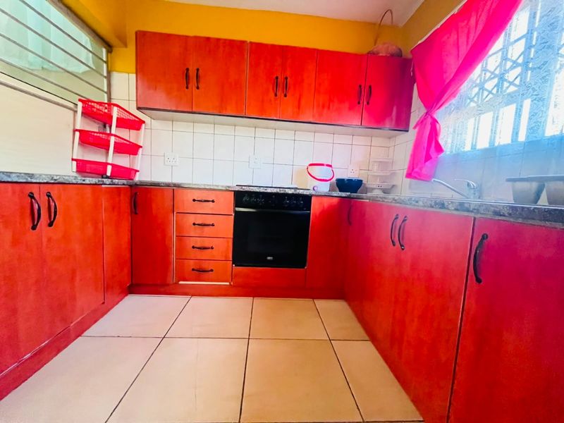 A functional kitchen featuring built-in cabinetry, a built-in oven, hob, tiled backsplash, and tiled flooring.