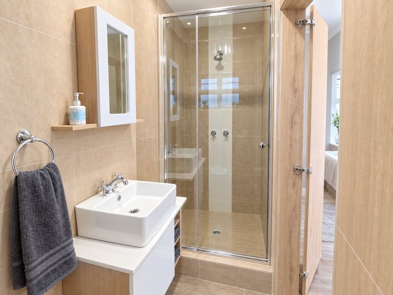 Modern bathroom featuring a vessel sink vanity, glass-enclosed shower, and neutral-toned wall and floor tiling.