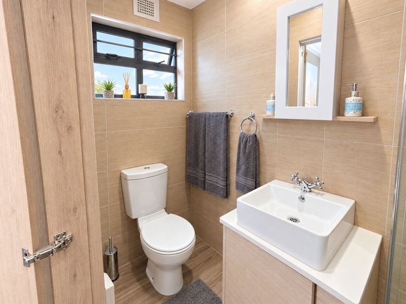 A modern, well-maintained bathroom featuring a vessel sink vanity, wall-mounted mirror cabinet, and neutral-toned wall and floor tiling.