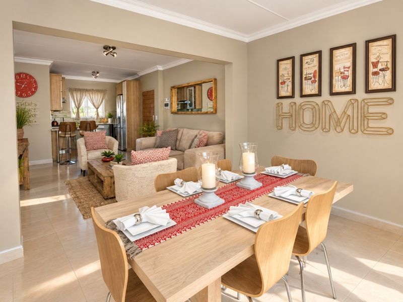 Spacious open-plan living and dining area featuring neutral tiled flooring, cove cornicing, and a well-integrated kitchen with modern cabinetry.