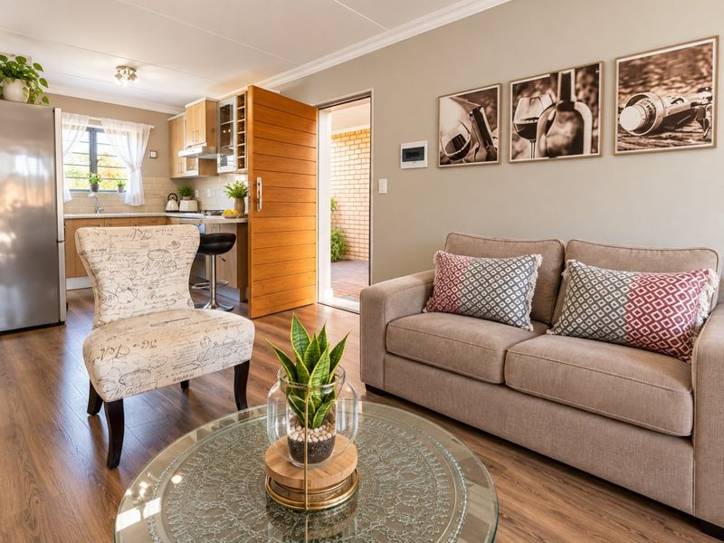 An open-plan living and kitchen area featuring laminate flooring, modern cabinetry, and direct access to an outdoor patio space.